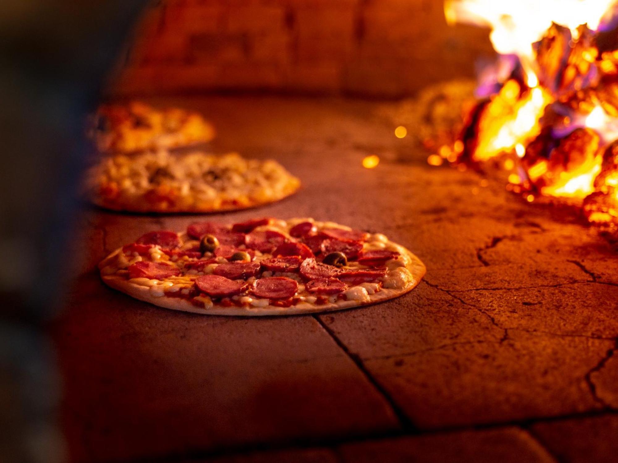 Ocean Palace All Inclusive Premium Natal Exteriör bild Pizza being cooked in a wood-fired oven